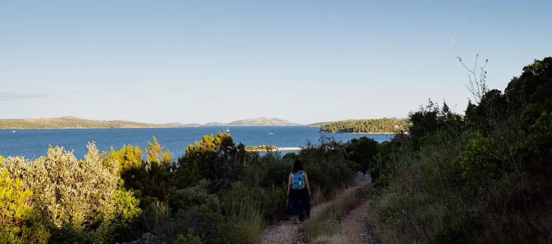 person walking on a scenic coastal path with ocean views